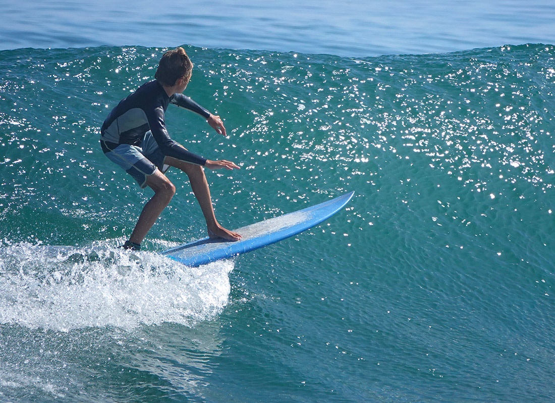 Blog - Young Surfer Riding Ocean Waves on a Sunny Day
